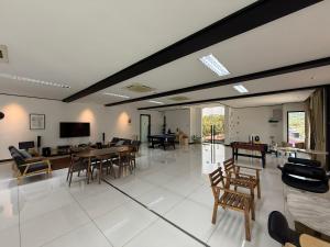 a living room with tables and chairs and a tv at Flamingo Homestay Port Dickson in Port Dickson