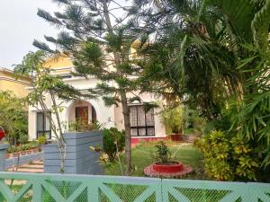 a house with a palm tree in the yard at Surabhi Gardenia 28B-C in Raichak