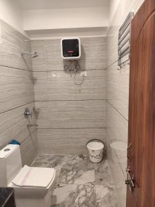 a bathroom with a toilet and a tv on the wall at HOTEL GREENERY VIEW in Gangtok +32 photos