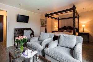 a living room with two couches and a bed at Home Hotel Park in Halden