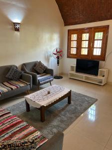 a living room with a couch and a table and a tv at The House Of Love in Luxor