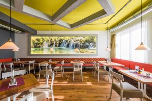 un ristorante con tavoli e sedie e un grande dipinto sul muro di Gasthof Niki a Kapfenberg