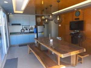 a dining room with a wooden table and a kitchen at Beachfront With 2 Bedrooms and Pool for 20 in San Juan +14 photos
