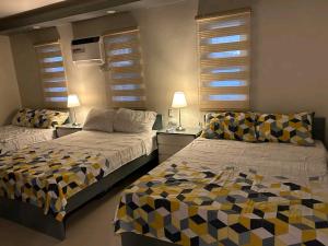 a bedroom with two beds and two lamps and windows at Beachfront With 2 Bedrooms and Pool for 20 in San Juan