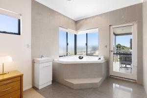a bathroom with a tub and a sink and windows at Walk to the Mandurah Foreshore & Marina in Mandurah +12 photos