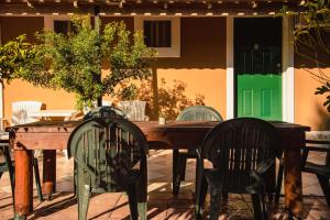 a wooden table with two chairs and a table with at Gardenos Hotel in Vitalades
