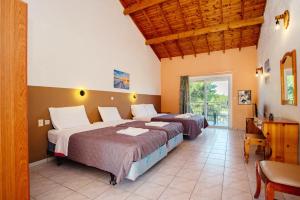 a bedroom with two beds and a desk and a window at Gardenos Hotel in Vitalades +94 photos