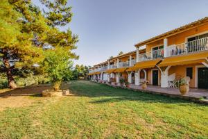 a row of buildings with trees and grass at Gardenos Hotel in Vitalades