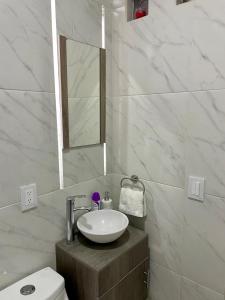 a bathroom with a sink and a toilet and a mirror at Moderno departamento en Tula in Tula de Allende +23 photos