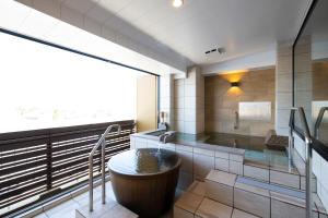 a bathroom with a tub and a large window at Mt Fuji Hanayagi no Sho Keizan in Fuefuki