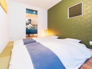 a bedroom with a large bed with a wave in the window at 巡り宿香西本町-最大10名 in Takamatsu