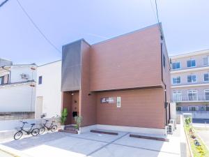 a brown building with bikes parked outside of it at 巡り宿香西本町-最大10名 in Takamatsu
