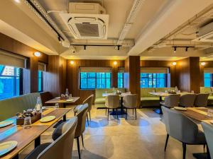 a restaurant with tables and chairs and windows at Zip by Spree Hotels Shirdi - Walkable Distance from Sai Baba Temple in Shirdi