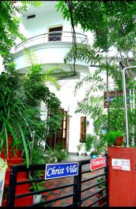 a white building with plants in front of it at ChristVille in Cochin