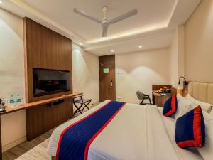 a hotel room with a bed and a flat screen tv at Zip by Spree Hotels Shirdi - Walkable Distance from Sai Baba Temple in Shirdi