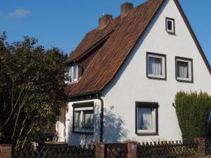 uma casa branca com um telhado castanho em Ferienhaus Snevern em Schneverdingen