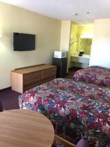 a hotel room with a bed and a flat screen tv at Relax Inn in Albany