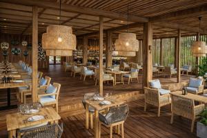 a restaurant with wooden floors and tables and chairs at Kappa Senses Zanzibar in Pwani Mchangani