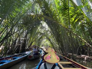 a group of people riding on boats in the water at H2T Home in Ho Chi Minh City