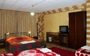 a hotel room with two beds and a television at Rocky Mountain Hotel Jordan in Petra