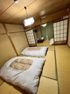 a room with two beds in a room with windows at 苗場ウッドインだいまる in Yuzawa