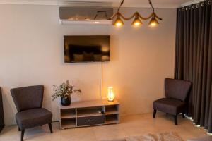 a living room with two chairs and a tv at Harmony House in Ladysmith