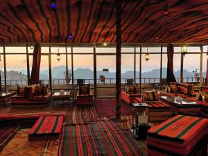 a large room with couches and tables and windows at Rocky Mountain Hotel Jordan in Petra