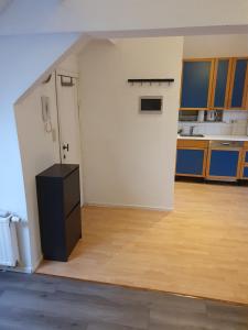 an empty room with a white wall and a kitchen at Studio meublé in Zaventem