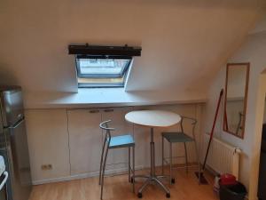 a small kitchen with a table and two stools at Studio meublé in Zaventem +2 photos