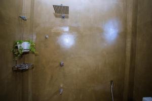 a bathroom with a brown wall with a shower at Seyoo Villa in Ahangama +63 photos