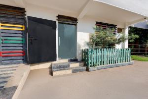 a house with a fence and a door at Super Hotel O Dadri Main Road Greater Noida in Greater Noida