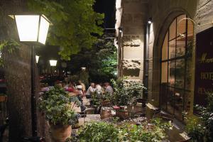 a group of people sitting at a restaurant with plants at Hotel Mariandl in Munich
