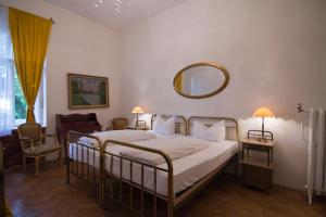 Schlafzimmer mit einem Bett und einem Wandspiegel in der Unterkunft Hotel Mariandl in München