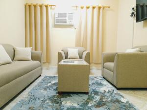 a living room with two couches and a table at أجاويد 1 Ajaweed in Salalah