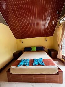 a bedroom with a bed with blue bows on it at MAHADING cottages in Gili Meno