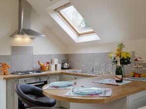 a kitchen with a sink and a table with chairs at Magpie's Rest in Horrabridge