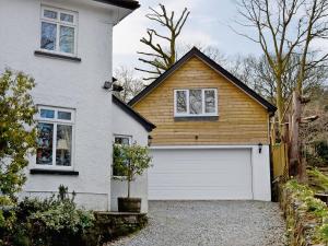 a white house with a white garage door at Magpie's Rest in Horrabridge +2 photos