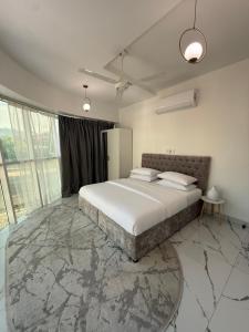 a bedroom with a bed with a marble floor at Bujalux apartment in Muscat +10 photos