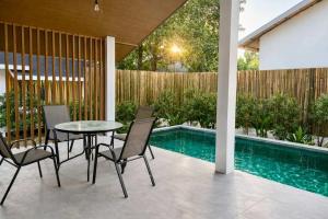a patio with a table and chairs next to a swimming pool at Cocolane Villa 4 in Hinkong