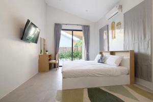a bedroom with a bed and a tv on a wall at Cocolane Villa 4 in Hinkong