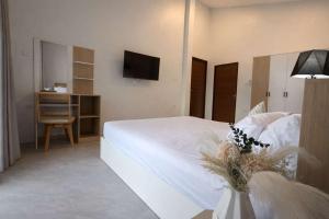a bedroom with a white bed and a tv at Cocolane Villa 4 in Hinkong +3 photos