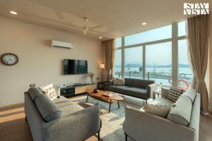 a living room with two couches and a tv at StayVista at Crimson Bleu - Bonfire & Pet Friendly in Pune