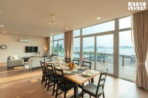 a dining room and living room with a table and chairs at StayVista at Crimson Bleu - Bonfire & Pet Friendly in Pune