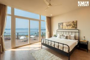 a bedroom with a bed and a large window at StayVista at Crimson Bleu - Bonfire & Pet Friendly in Pune +30 photos