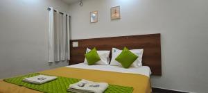 a bedroom with a bed with green and white pillows at Royal Green Residency Chennai Airport in Chennai +32 photos