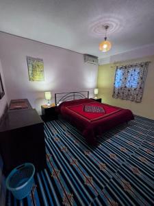 a bedroom with a red bed and a large rug at Rocky Mountain Hotel Jordan in Petra