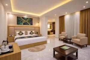 a hotel room with a large bed and a desk at Hotel Decent Suites - Delhi Airport in New Delhi +109 photos