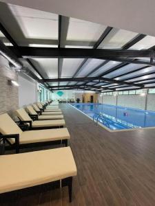 a swimming pool with a row of tables and chairs at Cozy Ski-In Studio near forest at Crystal residence in Bakuriani