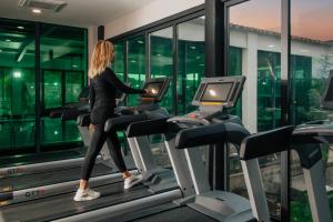 a woman running on a treadmill in a gym at Cozy Ski-In Studio near forest at Crystal residence in Bakuriani