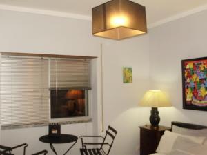 a living room with a lamp and a table and chairs at Miguel Torga Room in Coimbra